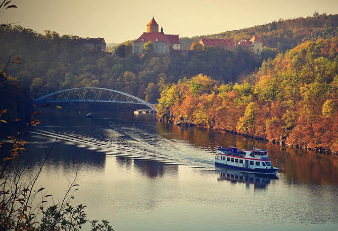 Castle Veveri - City of Brno, Czech Republic - Europe. Beautiful autumn landscape with castle. Brno dam with boat and sunset at the golden hour. Autumn season October.