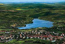 Hladina umělého jezera obklopená Podkomorskými lesy